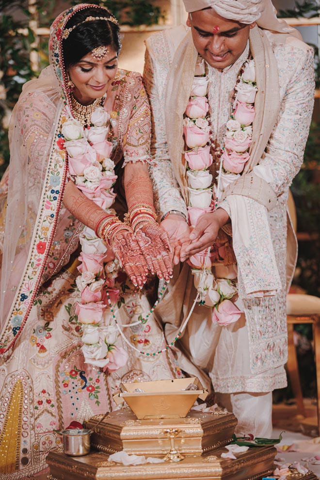 The bride and groom participate in rituals during their traditional Hindu ceremony.