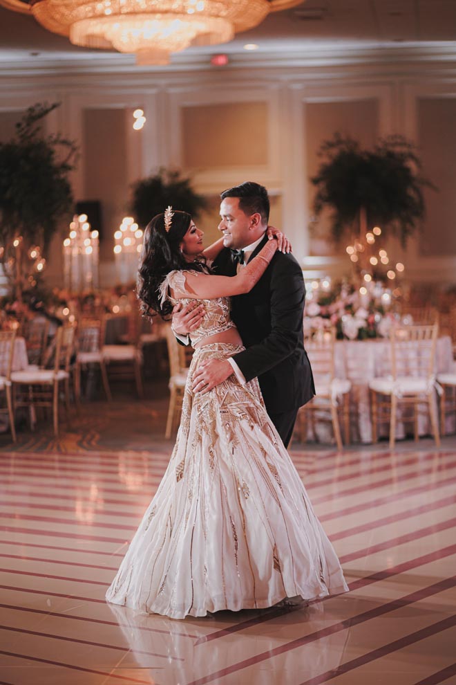 The bride and groom dance on the dance floor at their ballroom reception.