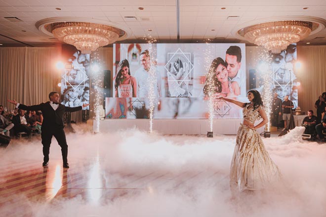 The bride and groom dance under sparklers in front of their wedding guests.