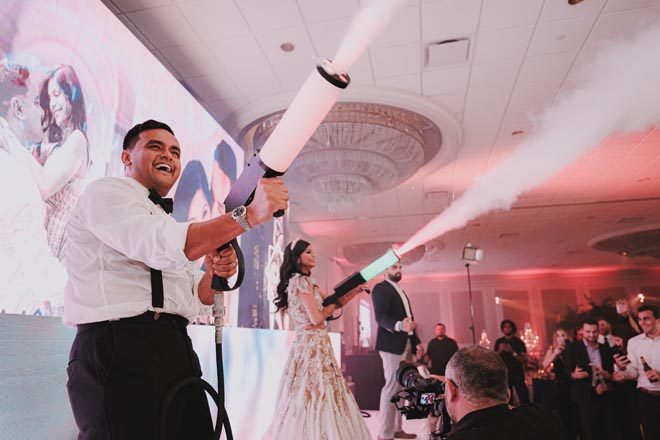 The bride and groom celebrate with their friends and family at their ballroom reception.