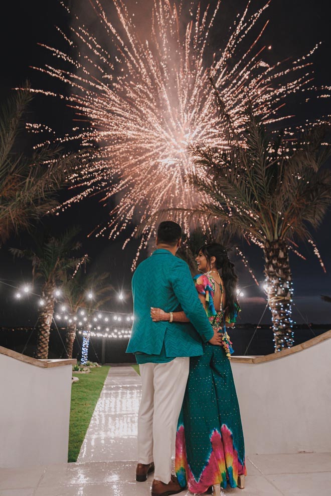 The bride and groom look up at the fireworks during their Mehndi ceremony.