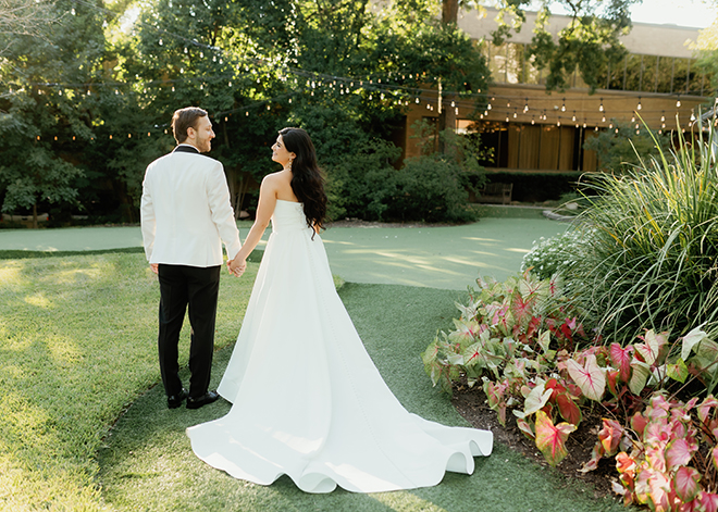 The bride and groom holding hands and looking at each other in front of The Houstonian Hotel, Club & Spa. 