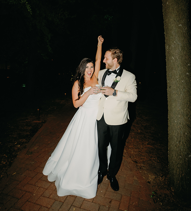 The bride cheering while the groom smiles at her outside The Houstonian Hotel, Club & Spa. 