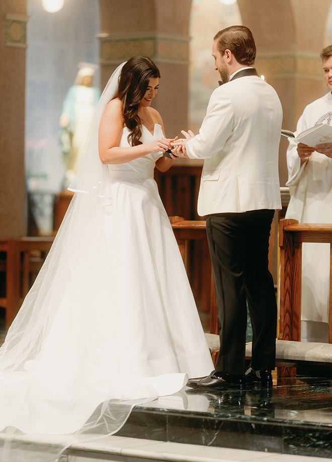 The bride and groom putting the rings on each others fingers at their traditional wedding ceremony. 