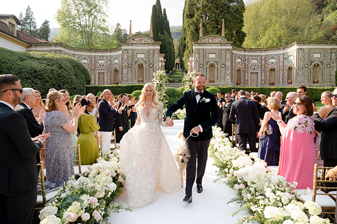 The bride, groom and their dog walking back down the aisle after their wedding ceremony. 