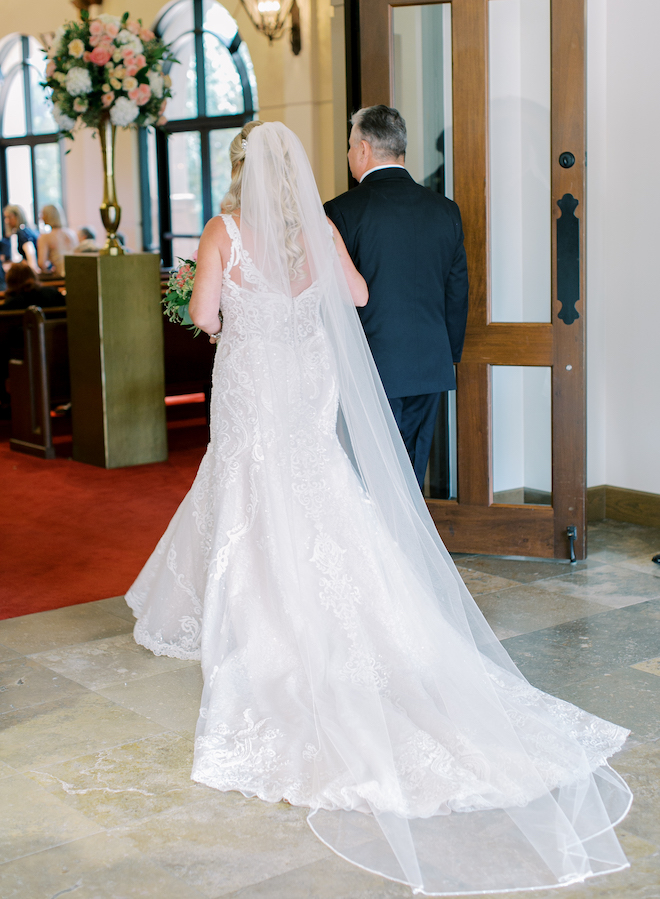 A bride and a man walking into a church ceremony about to go down the aisle. 