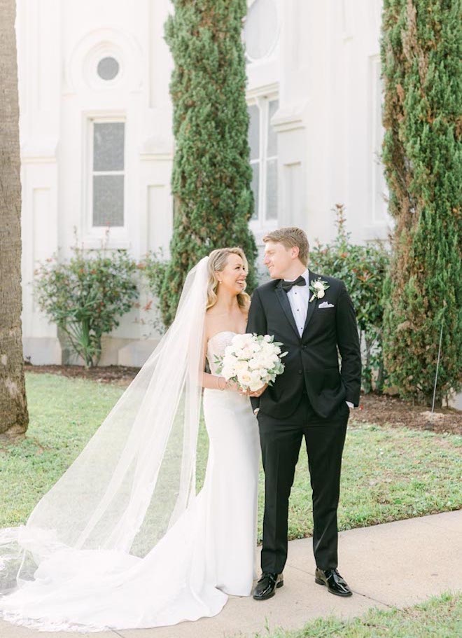 The bride and groom smile at each other after their church ceremony.