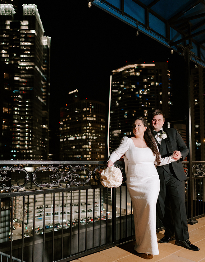 The bride and groom standing on the rooftop of the Hotel ICON. 