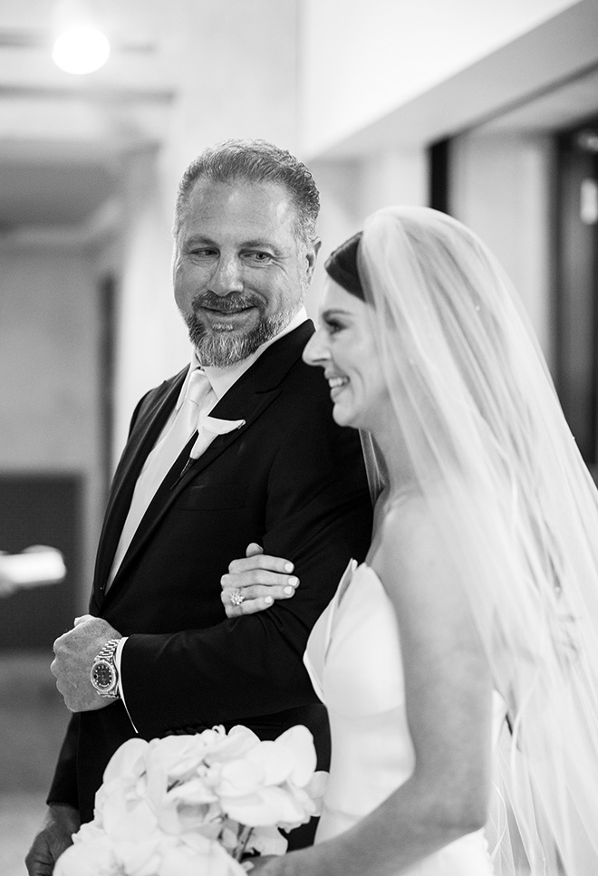 The father of the bride looks at his daughter before walking her down the aisle at her traditional church ceremony.