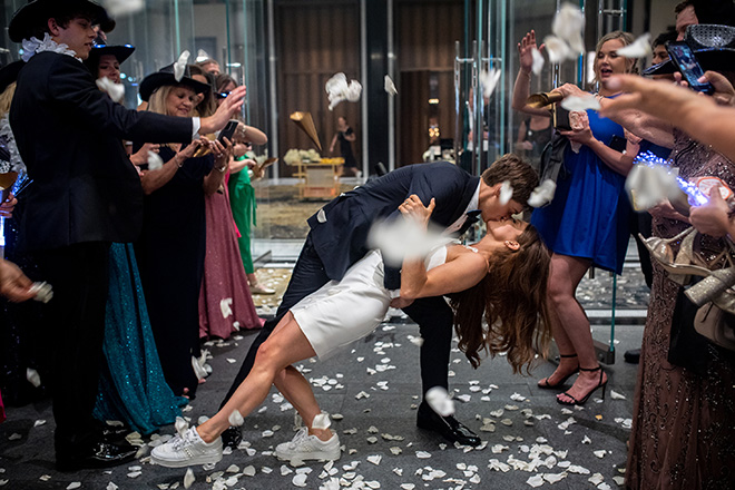 The bride and groom share a kiss at their rose petal send-off.