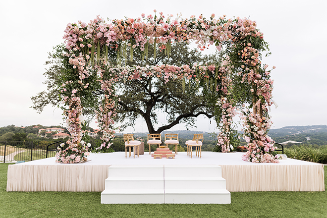 A mandap covered in pink flowers and greenery at Omni Barton Creek Resort & Spa.