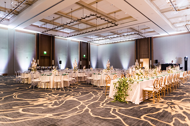 A ballroom at Omni Barton Creek Resort & Spa with round tables and a long reception table. 