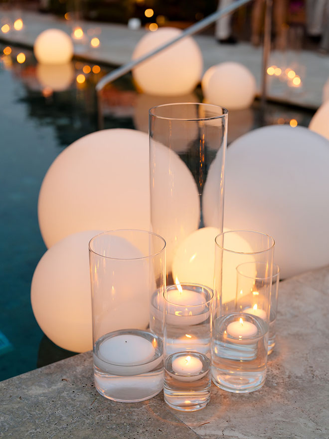 Pillar candles decorate the perimeter of the pool at the chic welcome dinner in Lake Como, Italy.