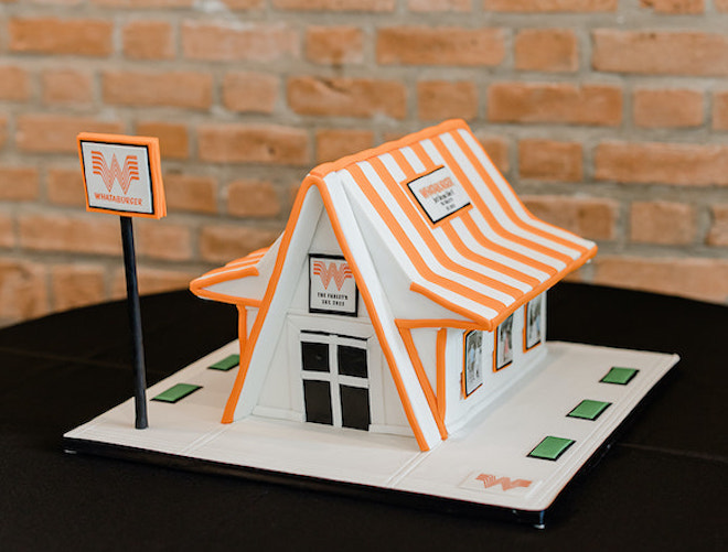 A groom's cake designed as a Whataburger building with the colors orange and white. 