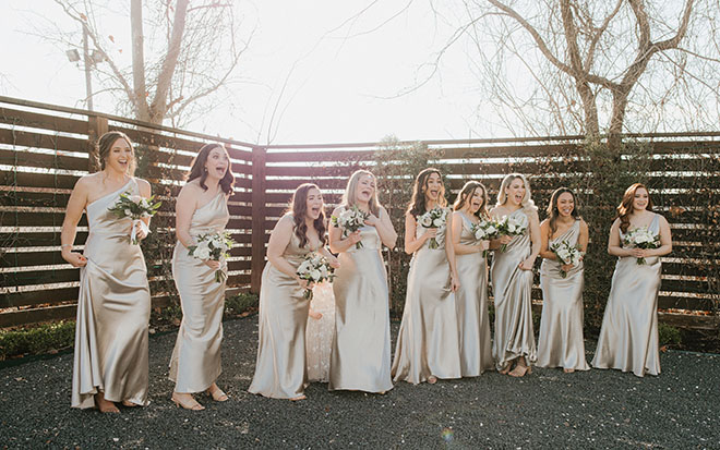 The bridesmaids react to seeing the bride in her wedding dress.