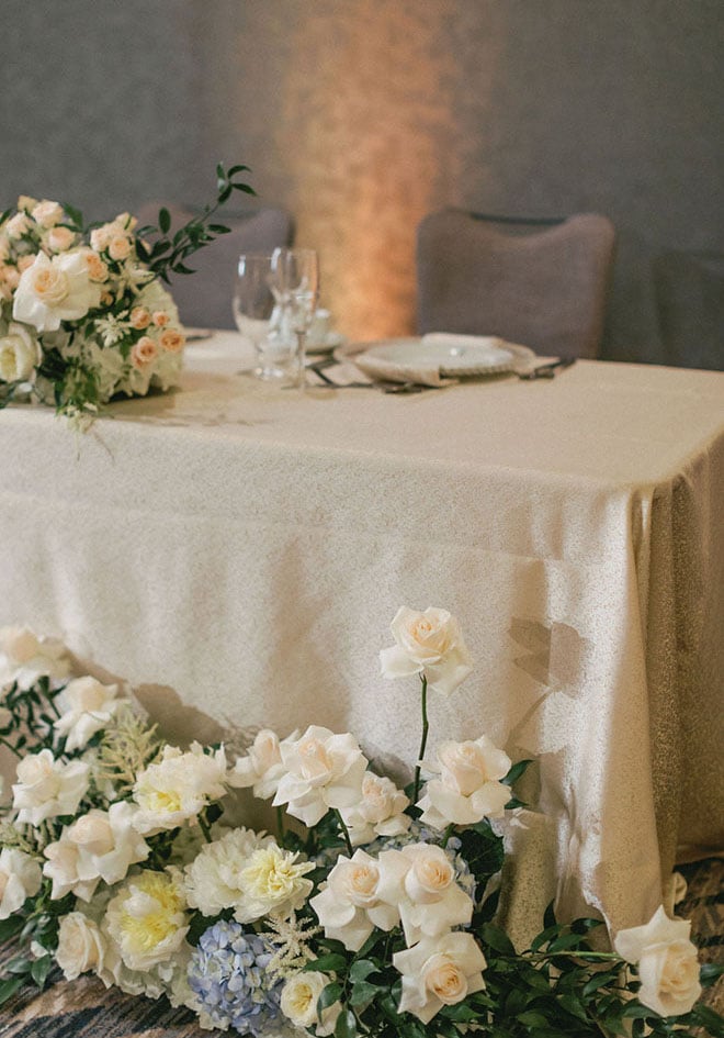 White roses decorate the sweet heart table at the blue-inspired wedding editorial.