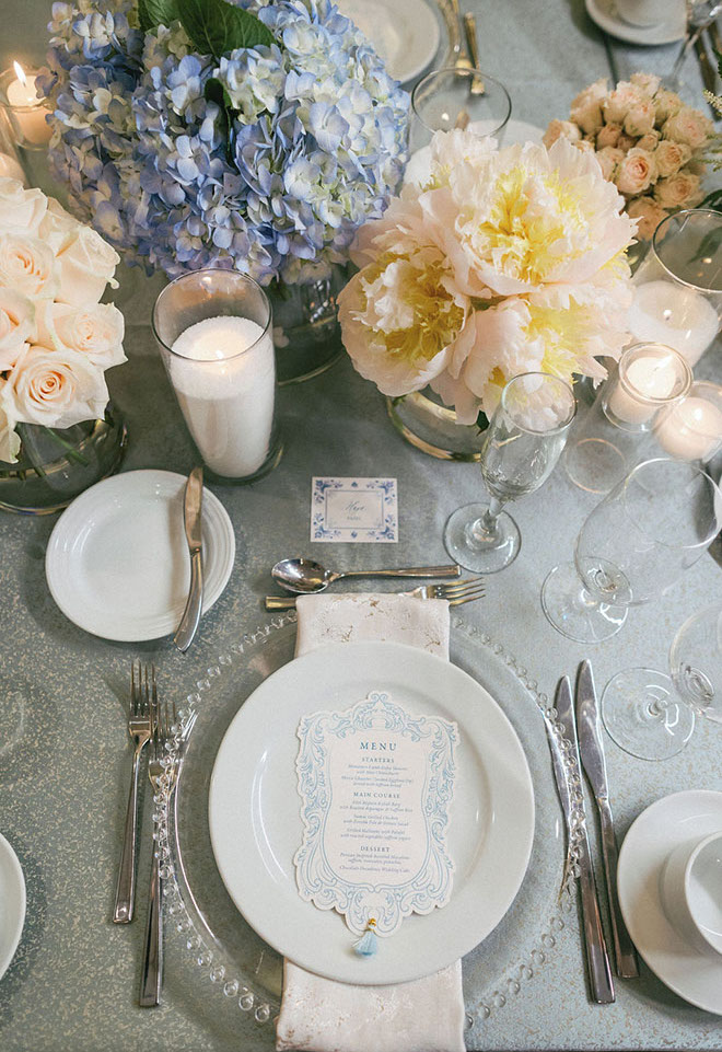 Candle light, blue hydrangeas and peonies decorate the reception tables.