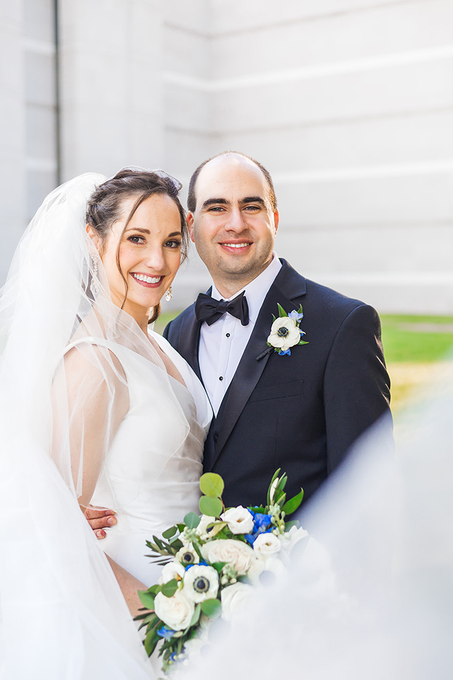 The bride and groom smile closely as they take their wedding photos. 