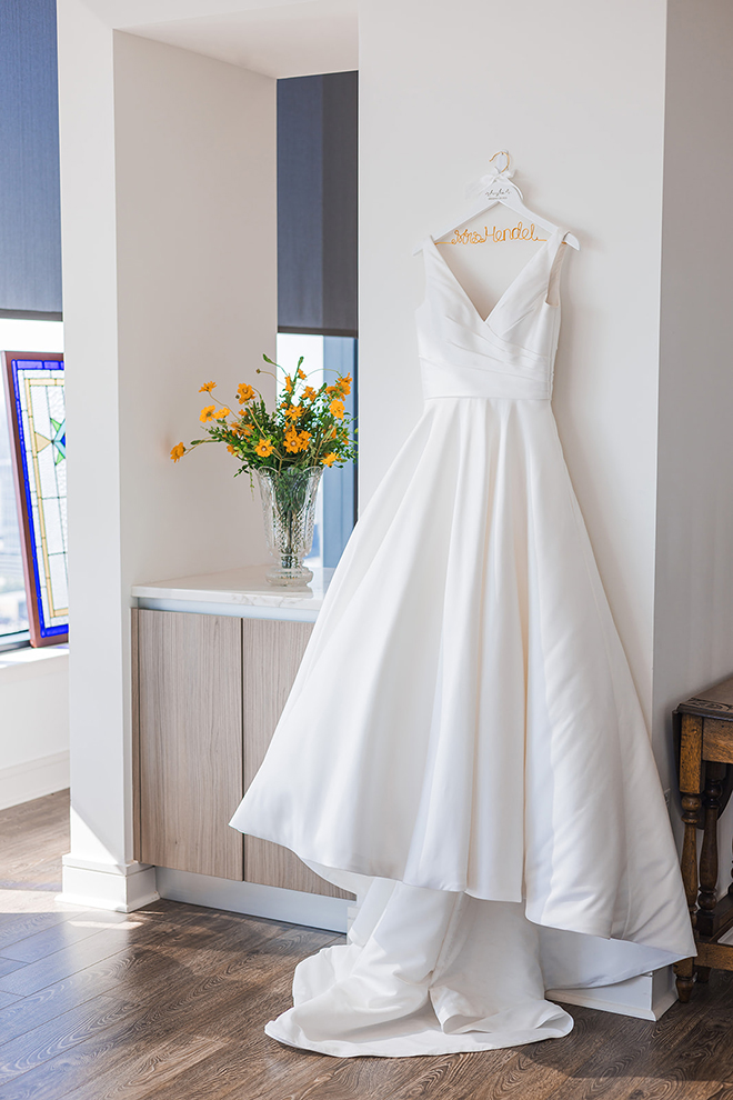 The brides wedding dress hung while she is getting ready. 