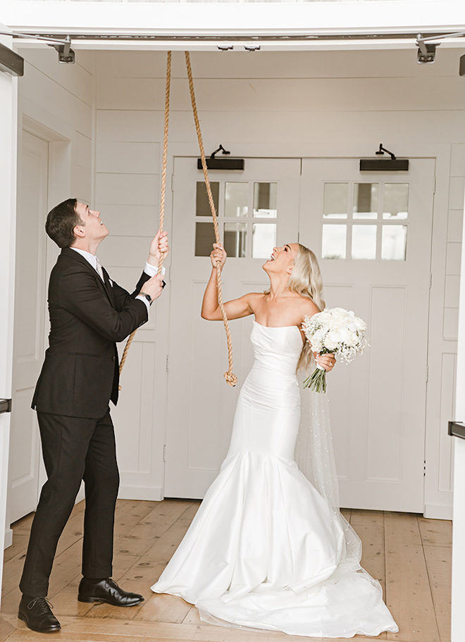 The bride and groom ring the church bell at the venue. 