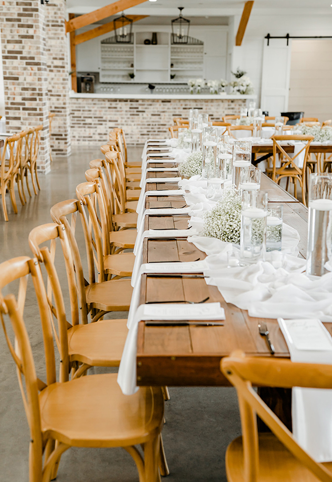 The wedding reception tables are decorated in white and champagne. 