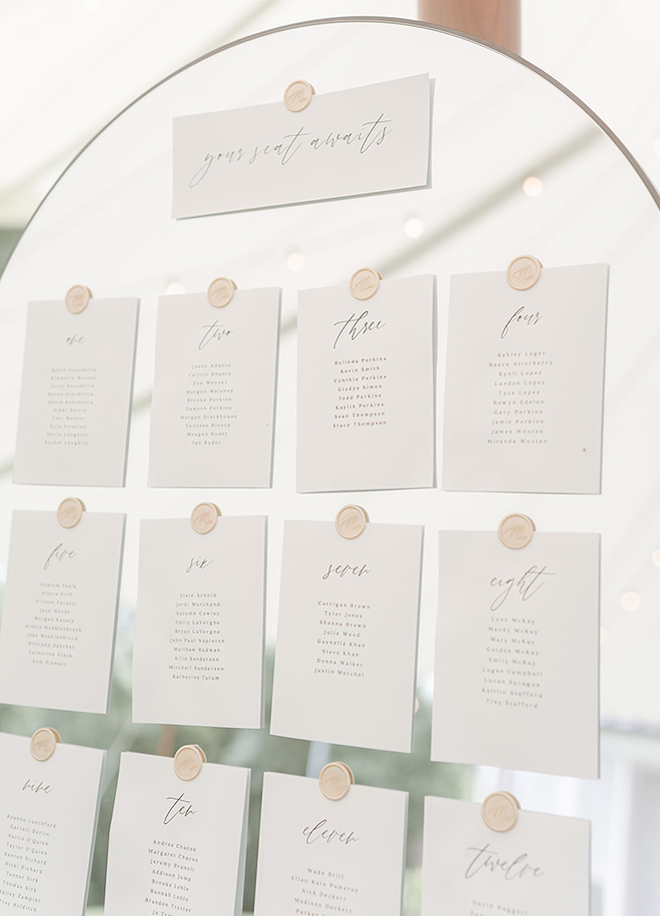 The guest seat arrangements are pasted on a mirror at the wedding reception. 