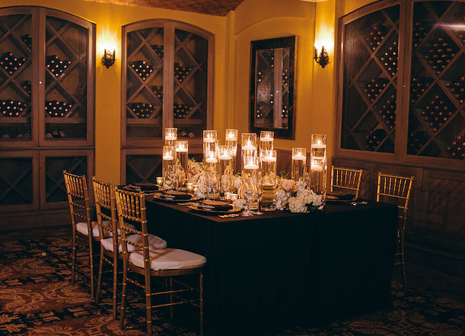 A photo of the inside of the the vault inside the hotel, very dark and intimate dinner reception table. 