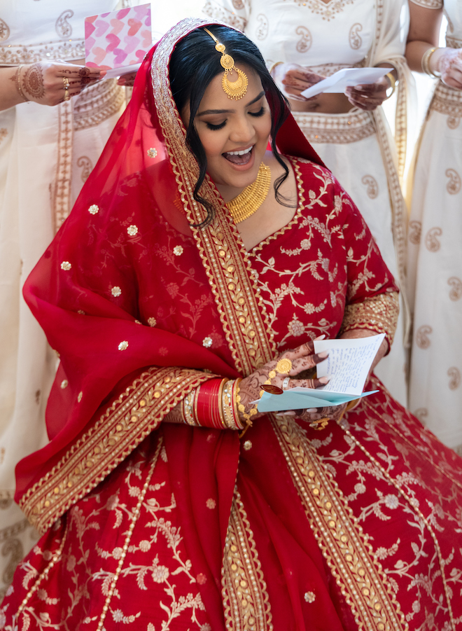 The bride smiling while reading a letter. 