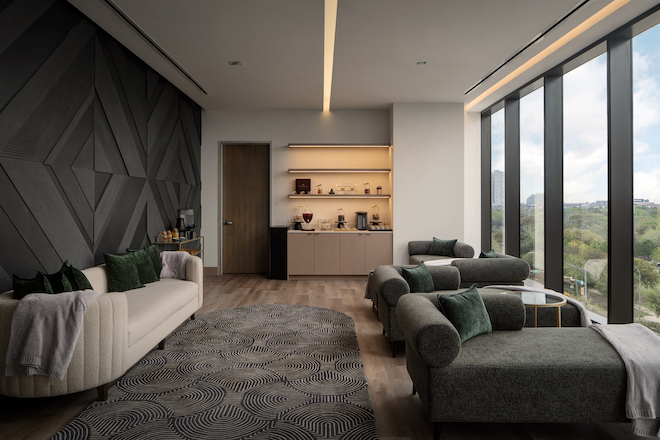 The grounding room at the Thompson Spa with floor-to-ceiling windows and green and cream lounge chairs. 